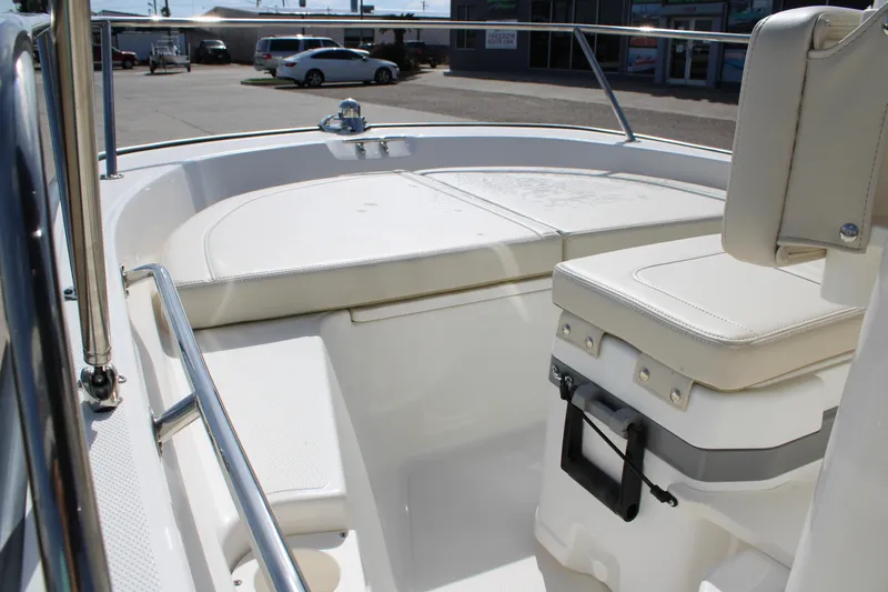 Slide: The Image of 2026 Boston Whaler 150 Montauk boat interior with cushioned seating and stainless steel railing. - 6