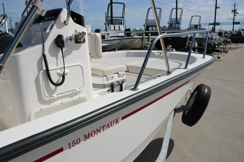Slide: The Image of 2026 Boston Whaler 150 Montauk boat on trailer, showcasing console and seating. - 8
