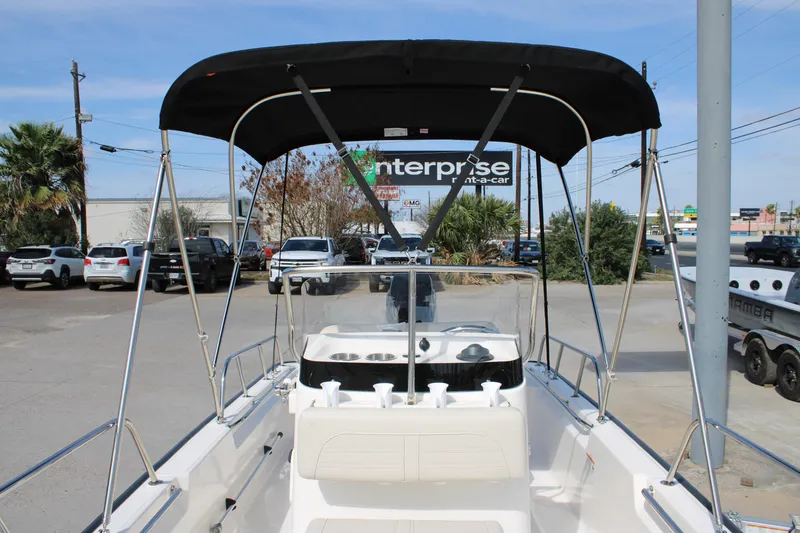 Slide: The Image of 2026 Boston Whaler 150 Montauk boat with canopy, parked in a lot. - 9