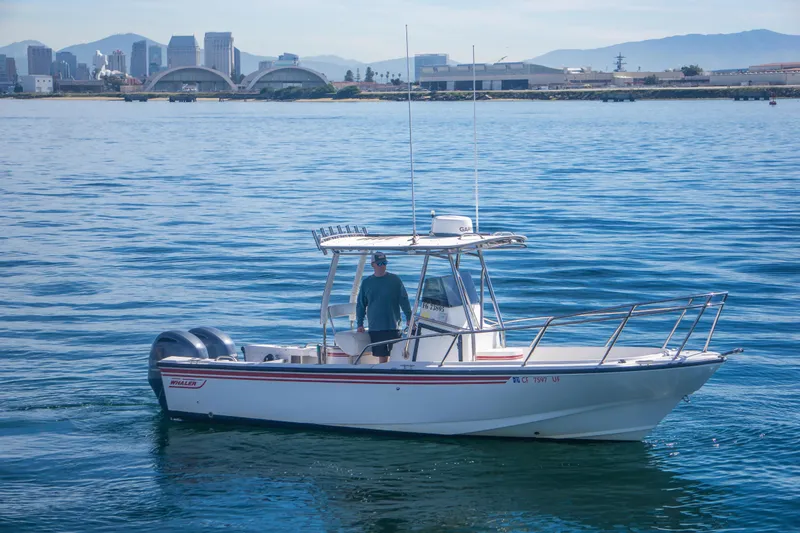 The Image of 1997 Boston Whaler 24 Outrage boat on calm water with city skyline in background. - 0