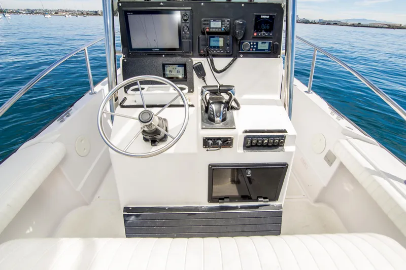 Slide: The Image of 1997 Boston Whaler 24 Outrage boat cockpit with steering wheel and navigation equipment. - 11