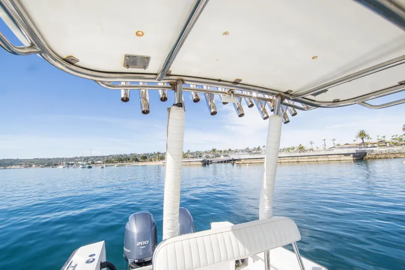 Slide: The Image of 1997 Boston Whaler 24 Outrage boat on calm water, featuring dual engines and coastal scenery. - 13