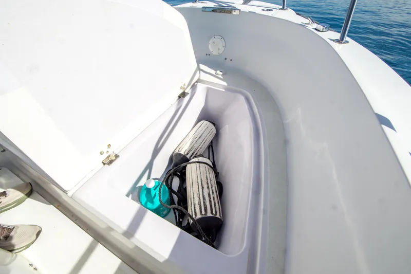 Slide: The Image of Open storage compartment on 1997 Boston Whaler 24 Outrage boat with fenders and cleaning supplies. - 19