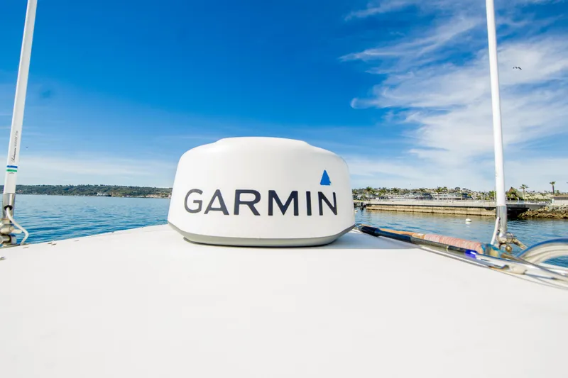 Slide: The Image of 1997 Boston Whaler 24 Outrage with Garmin equipment on calm water under blue sky. - 21