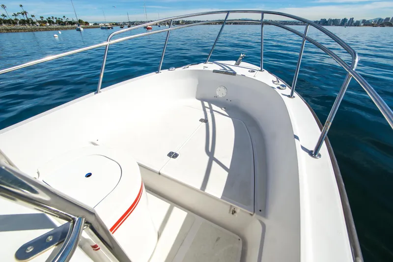 Slide: The Image of 1997 Boston Whaler 24 Outrage boat on calm water, featuring spacious deck and railing. - 6