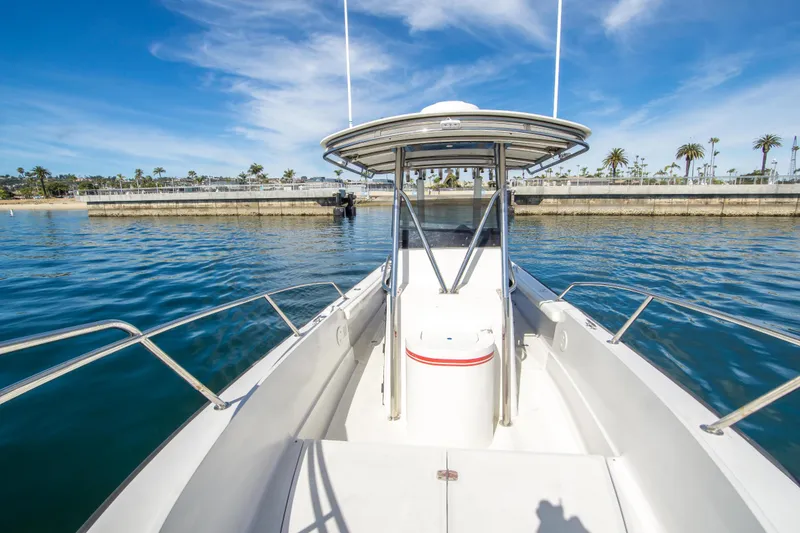 Slide: The Image of 1997 Boston Whaler 24 Outrage boat on calm water, clear sky, and palm trees in background. - 9