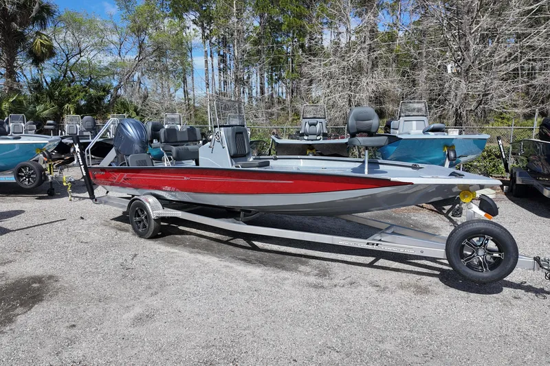 The Image of 2026 Xpress H22B Bay boat with red and gray design on a trailer. - 0