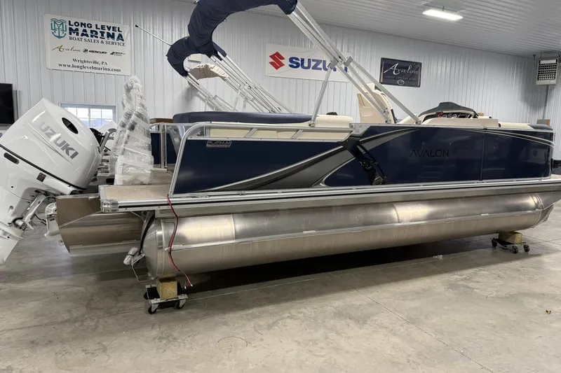 The Image of 2026 Avalon LSZ Elite 21' pontoon boat with Suzuki outboard motor in showroom. - 1