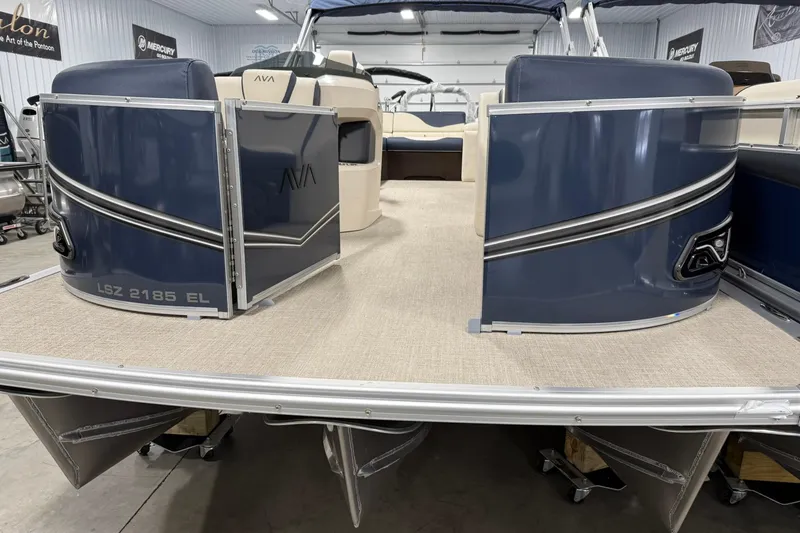 Slide: The Image of 2026 Avalon LSZ Elite 21' pontoon boat, blue exterior, spacious deck, indoor showroom. - 5