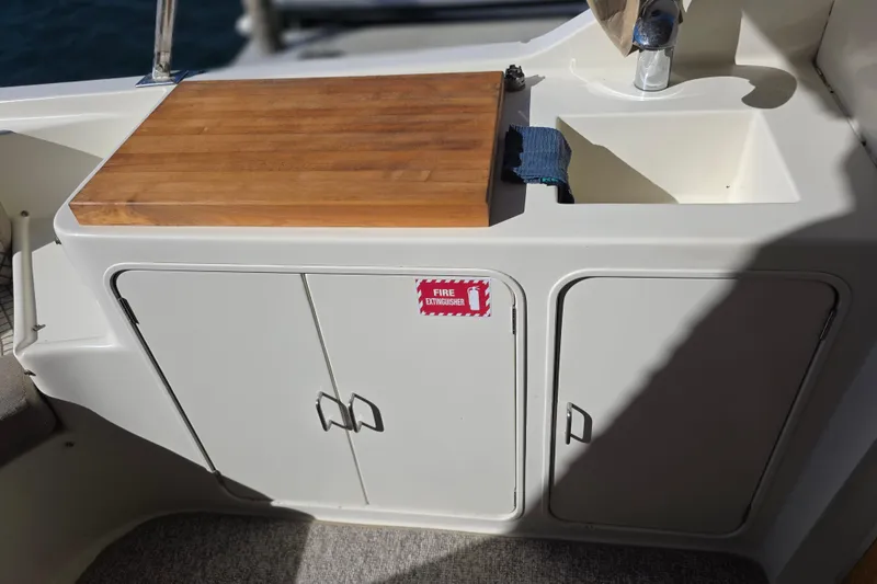 Slide: The Image of McKinna 48 Pilothouse 2000 boat kitchenette with wooden countertop and sink. - 11