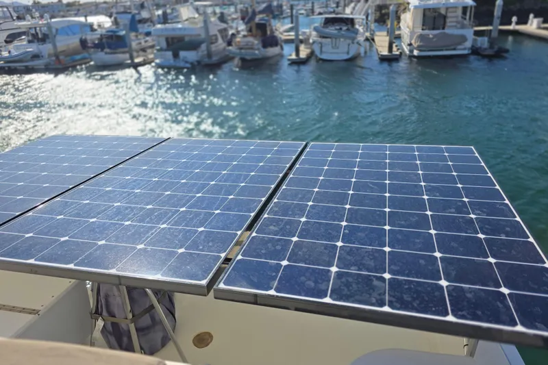 Slide: The Image of Solar panels on a 2000 McKinna 48 Pilothouse yacht in a marina setting. - 13