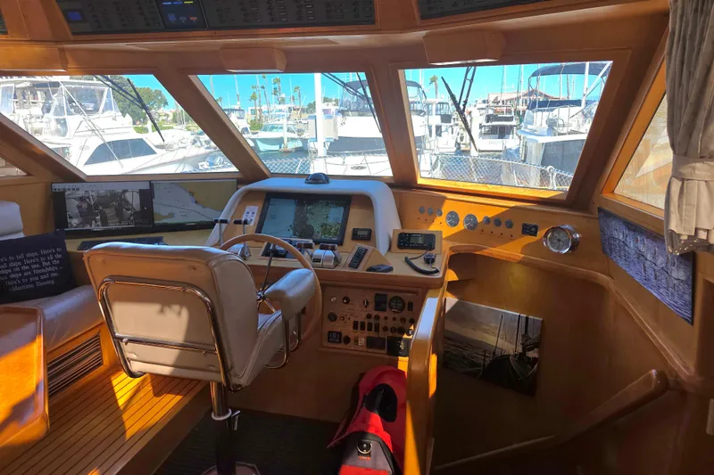 Slide: The Image of Pilothouse interior of 2000 McKinna 48, featuring navigation equipment and marina view. - 14