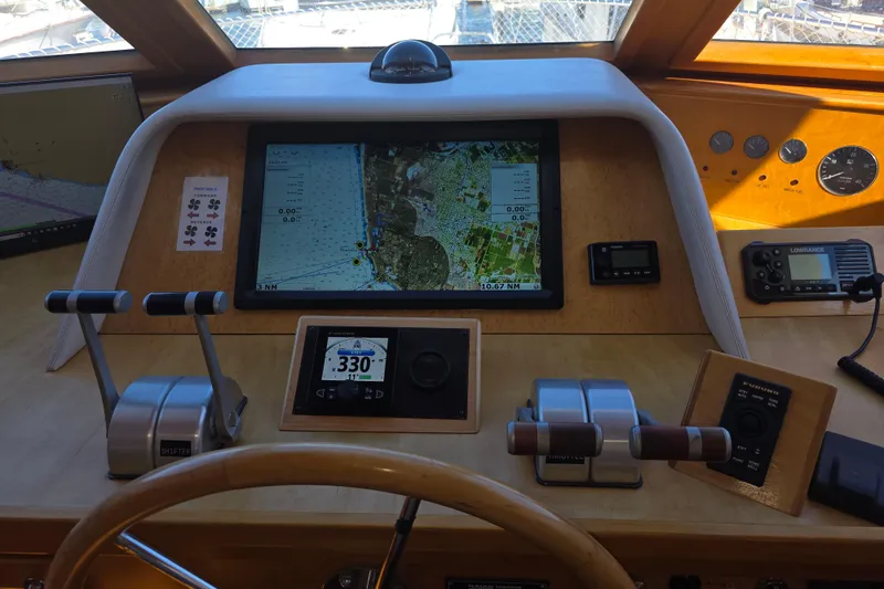 Slide: The Image of Pilothouse of 2000 McKinna 48, featuring navigation screens and control levers. - 15