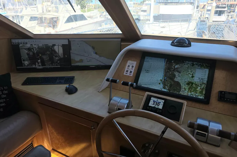 Slide: The Image of Pilothouse interior of 2000 McKinna 48, featuring navigation screens and controls. - 16