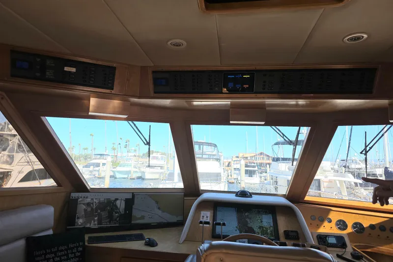 Slide: The Image of Pilothouse interior of 2000 McKinna 48, featuring navigation equipment and marina view. - 17