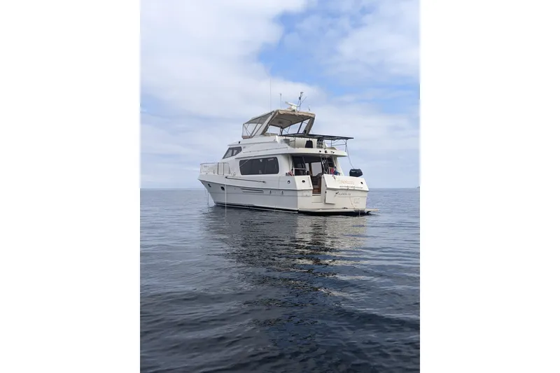 Slide: The Image of 2000 McKinna 48 Pilothouse yacht on calm ocean waters under a cloudy sky. - 2