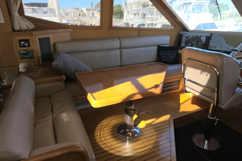 Slide: The Image of Interior of 2000 McKinna 48 Pilothouse with leather seating and wooden table. - 25