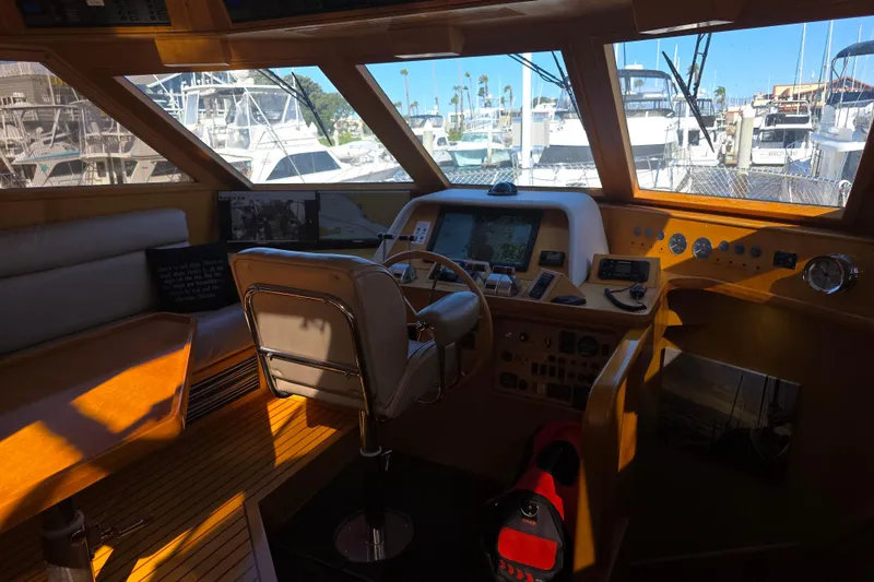 Slide: The Image of Pilothouse interior of 2000 McKinna 48, featuring navigation controls and marina view. - 26