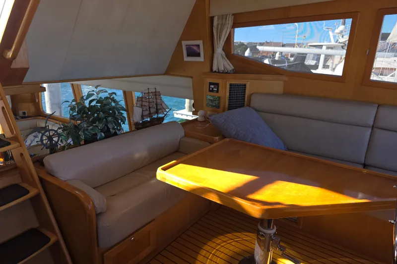 Slide: The Image of Interior of 2000 McKinna 48 Pilothouse yacht with cozy seating and wooden table. - 30