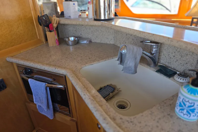 Slide: The Image of Kitchen area of a 2000 McKinna 48 Pilothouse yacht with sink and countertop. - 33
