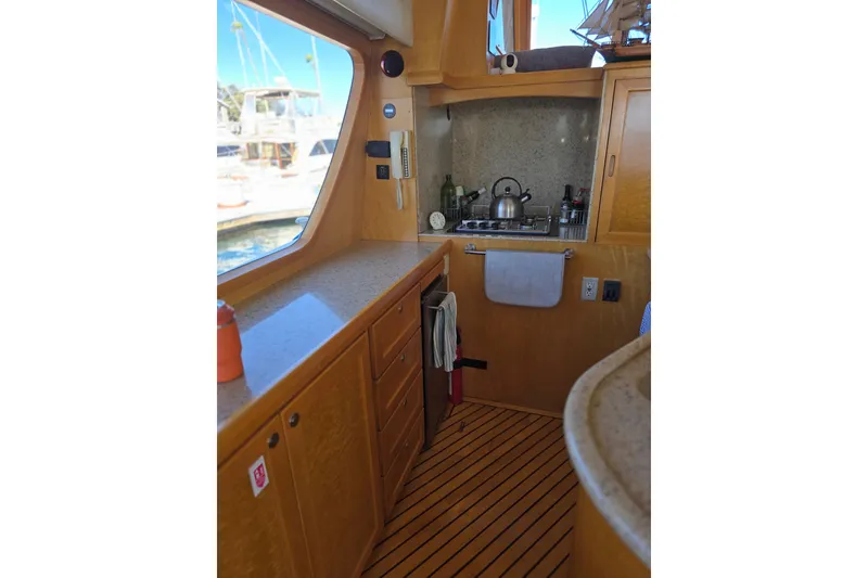 Slide: The Image of Interior of 2000 McKinna 48 Pilothouse yacht kitchen with wooden cabinetry and appliances. - 35