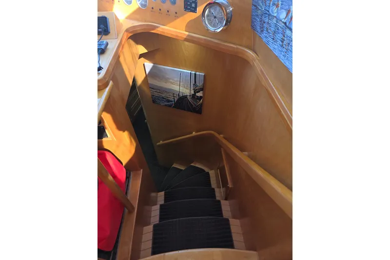 Slide: The Image of Staircase inside 2000 McKinna 48 Pilothouse yacht with wooden finish and nautical decor. - 37