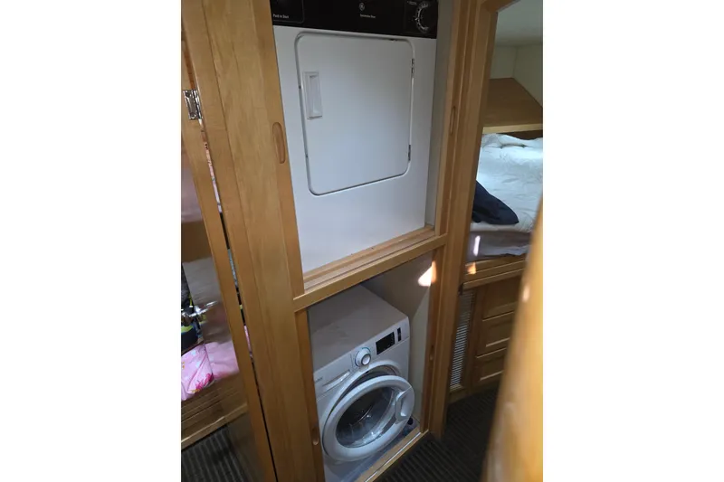 Slide: The Image of Laundry area inside 2000 McKinna 48 Pilothouse yacht, featuring washer and dryer. - 38