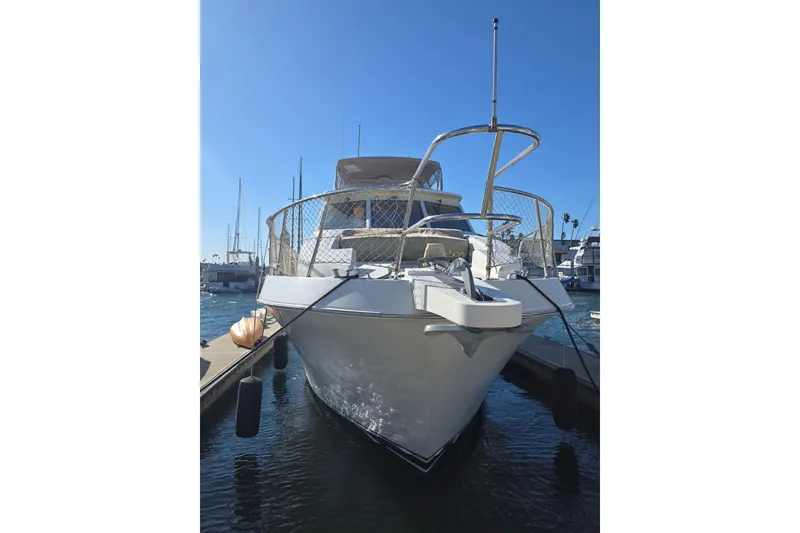 Slide: The Image of 2000 McKinna 48 Pilothouse yacht docked at marina under clear blue sky. - 4