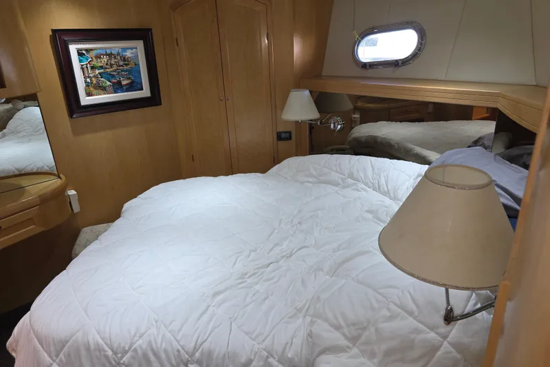 Slide: The Image of Cozy bedroom in 2000 McKinna 48 Pilothouse yacht with framed artwork and porthole window. - 40