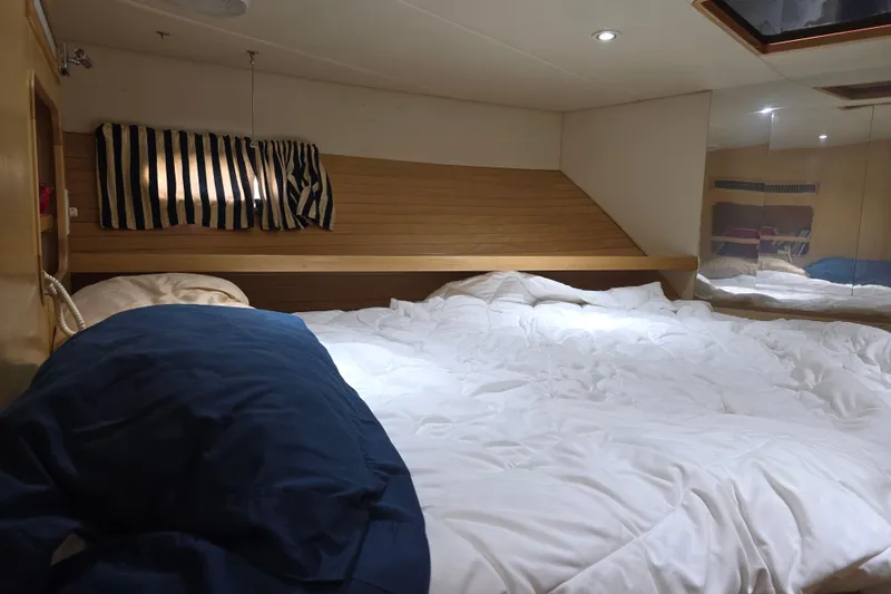 Slide: The Image of Cozy bedroom in 2000 McKinna 48 Pilothouse yacht with striped curtains and plush bedding. - 41