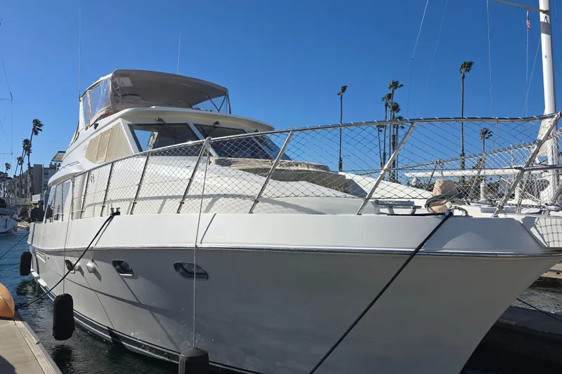 Slide: The Image of 2000 McKinna 48 Pilothouse yacht docked under clear blue sky. - 5