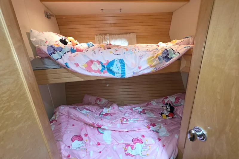 Slide: The Image of Bunk beds with colorful children's bedding in a 2000 McKinna 48 Pilothouse cabin. - 53