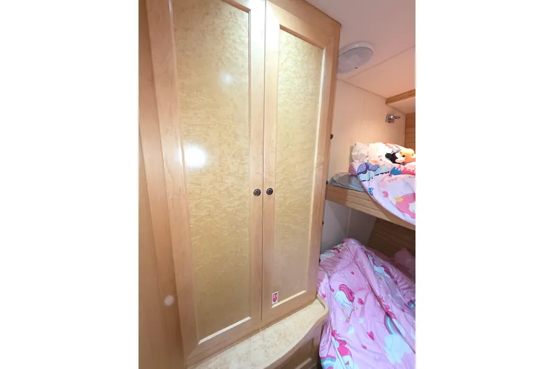 Slide: The Image of Interior of 2000 McKinna 48 Pilothouse with wooden cabinet and cozy bunk beds. - 54