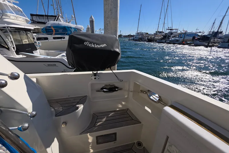 Slide: The Image of 2000 McKinna 48 Pilothouse yacht docked, featuring a Dickinson grill and scenic marina view. - 59