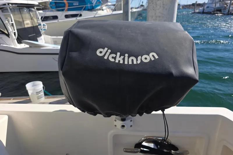 Slide: The Image of Cover on a McKinna 48 Pilothouse boat, featuring Dickinson branding, docked at a marina. - 61