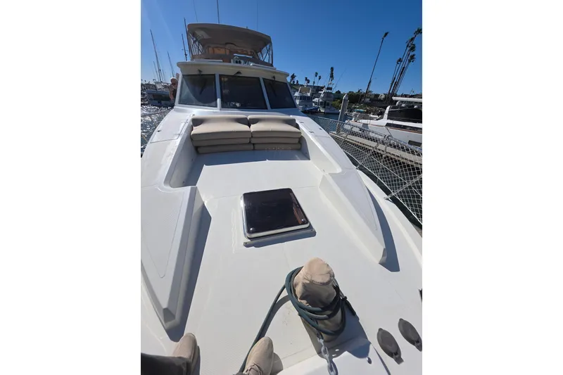 Slide: The Image of 2000 McKinna 48 Pilothouse yacht deck with seating, docked in a marina. - 75