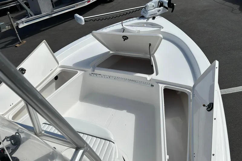 Slide: The Image of 2014 Tidewater 2100 Bay Max boat with open storage compartments and trolling motor. - 13
