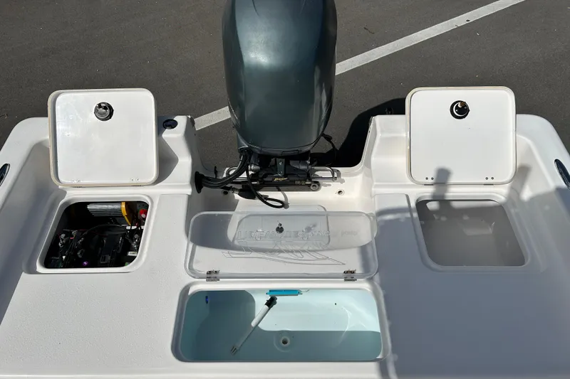 Slide: The Image of 2014 Tidewater 2100 Bay Max boat with open storage compartments and engine. - 15