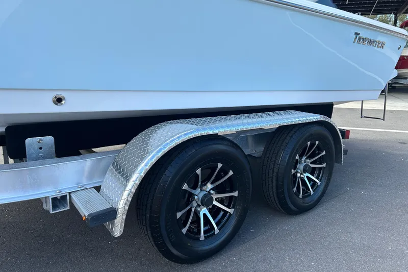 Slide: The Image of 2014 Tidewater 2100 Bay Max boat on a dual-axle trailer with alloy wheels. - 17