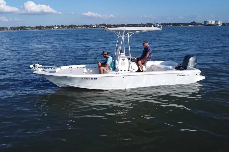 Slide: The Image of 2014 Tidewater 2100 Bay Max boat on calm water with two people aboard. - 18