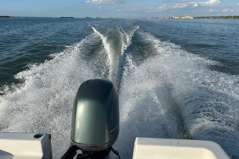 Slide: The Image of 2014 Tidewater 2100 Bay Max boat cruising on open water, leaving a wake. - 20