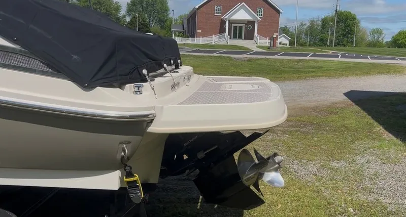Slide: The Image of 2010 Sea Ray 220 boat with cover, parked outdoors. - 13