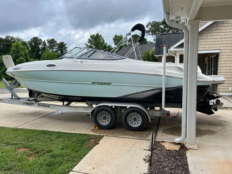 Slide: The Image of 2018 Stingray 235 LR boat on trailer in driveway. - 12