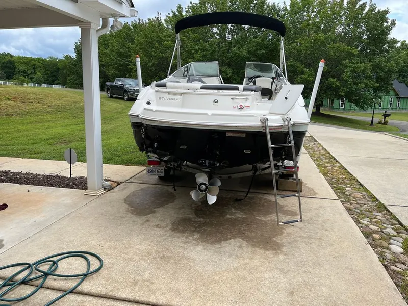 Slide: The Image of 2018 Stingray 235 LR boat parked on a driveway. - 13