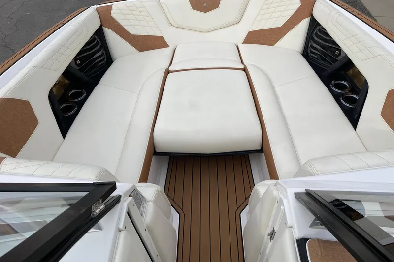 Slide: The Image of 2021 Nautique Super Air Nautique G25 boat interior with luxurious seating and cup holders. - 11