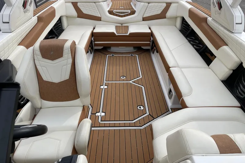Slide: The Image of 2021 Nautique Super Air Nautique G25 interior with luxurious seating and teak-style flooring. - 12