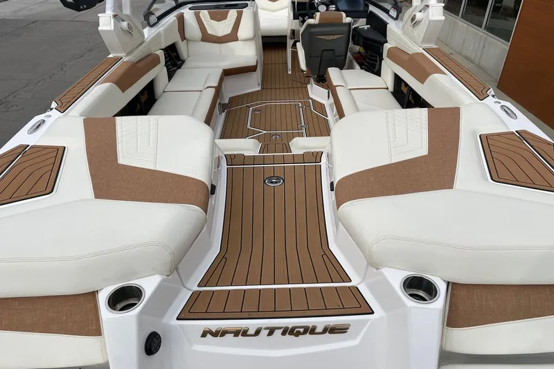Slide: The Image of 2021 Nautique Super Air Nautique G25 interior with luxurious seating and teak-style flooring. - 4