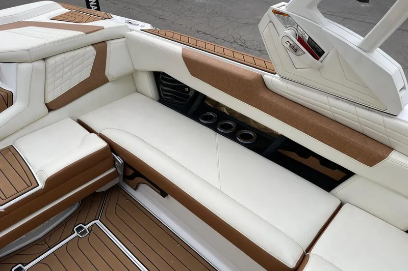 Slide: The Image of 2021 Nautique Super Air Nautique G25 interior with white and brown seating, cup holders, and teak flooring. - 9
