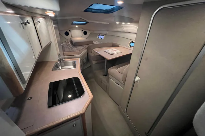 Slide: The Image of 1997 Maxum 2800 SCR boat interior with kitchenette, seating, and table. - 12