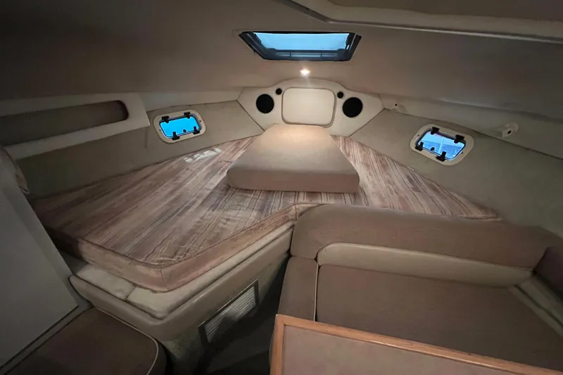 Slide: The Image of 1997 Maxum 2800 SCR cabin interior with cozy sleeping area and porthole windows. - 15